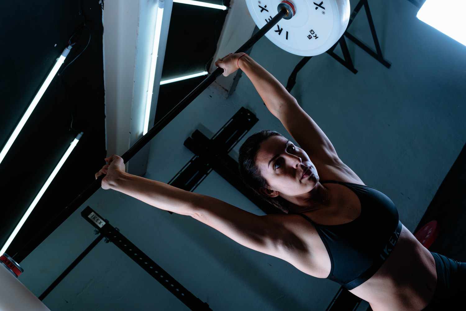 Atleta entrenando un movimiento de halterofilia con discos técnicos blancos IKEX