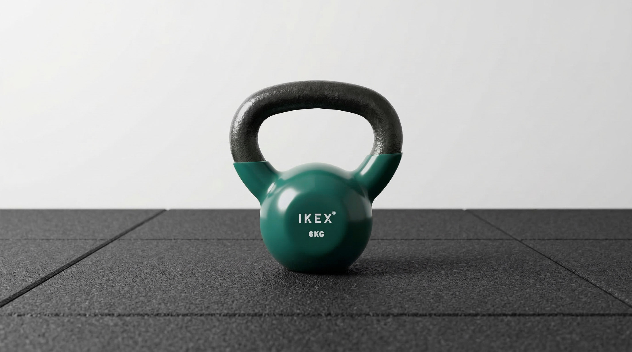 Kettlebell IKEX de vinilo de 6 kg con núcleo metálico, vista real sobre suelo deportivo