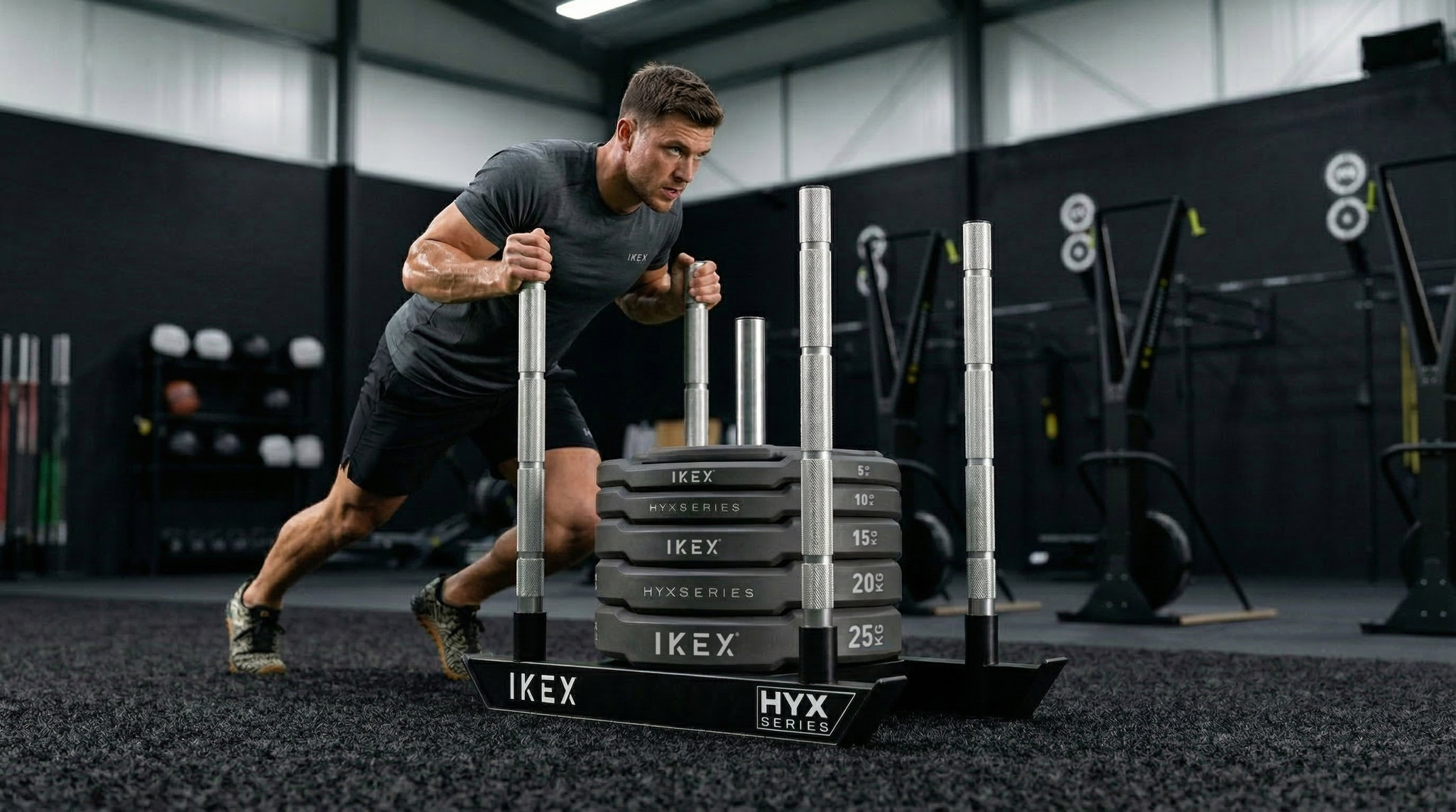 Atleta realizando un empuje con el trineo HYX IKEX cargado con discos en un gimnasio